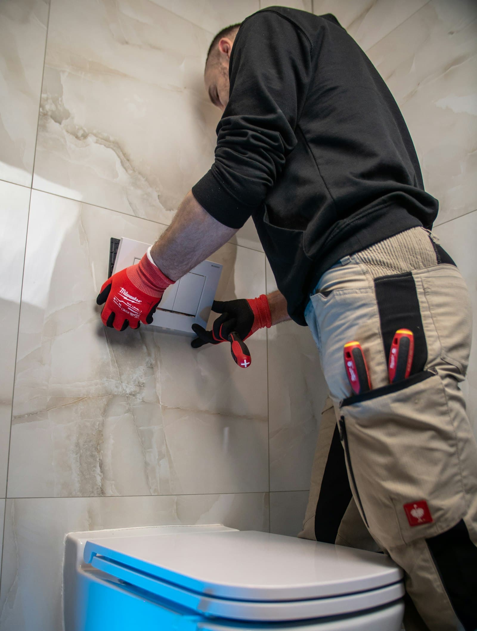 Loodgieter met werkhandschoenen monteert een toilet
